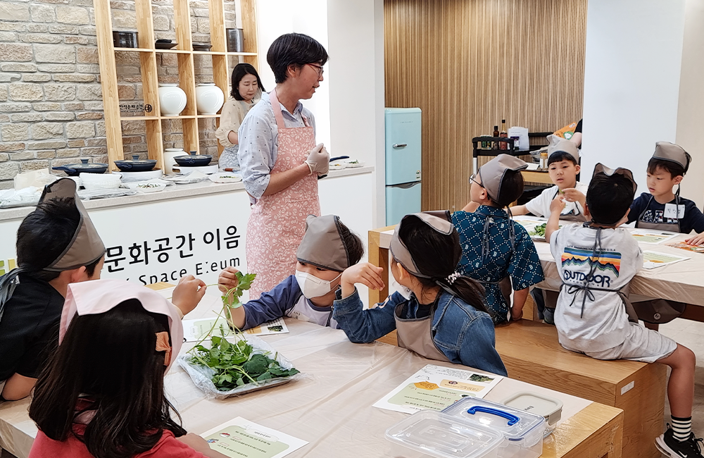 나물을 직접 만져보며 수업을 듣는 아이들