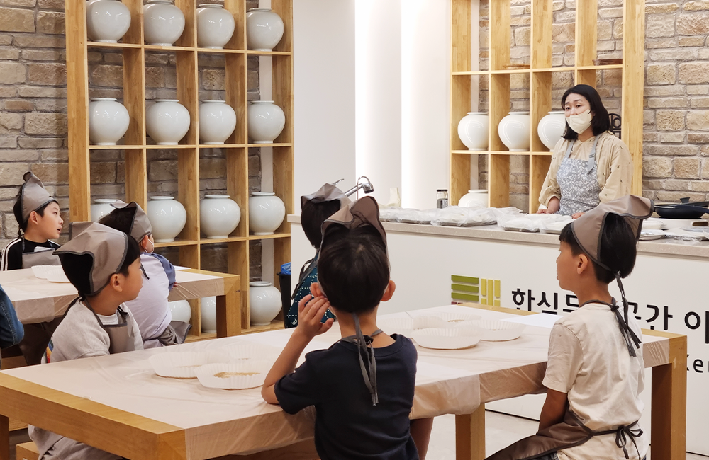 한식 스튜디오에 모여 앞치마를 하고 세시음식 수업을 듣고 있는 아이들