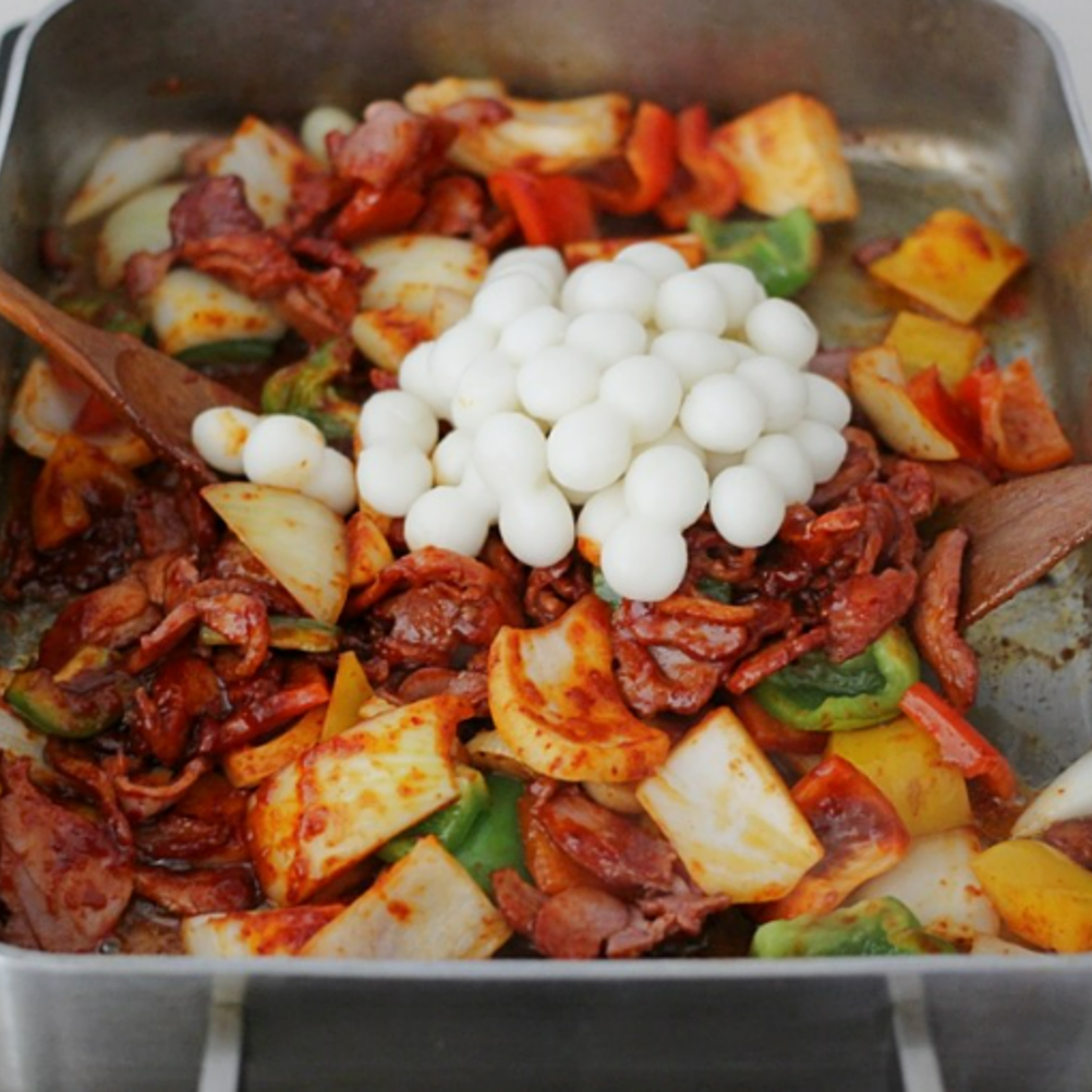 ③ 팬에 훈제오리를 굽다가 야채와 양념장, 데친 떡을 넣어 볶아준다.