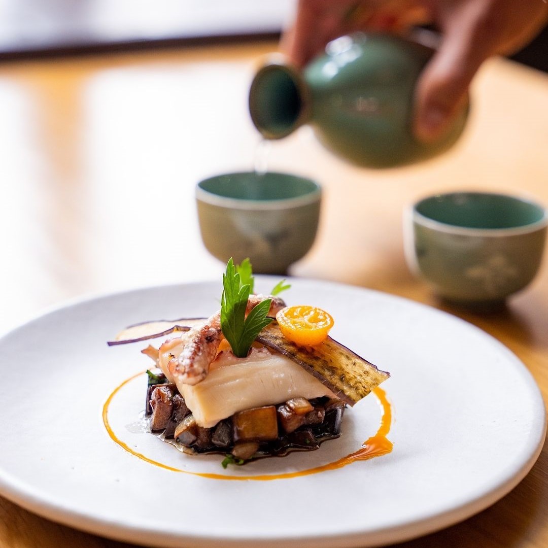 퓨전 한식요리 뒤로 청주를 따르는 이미지